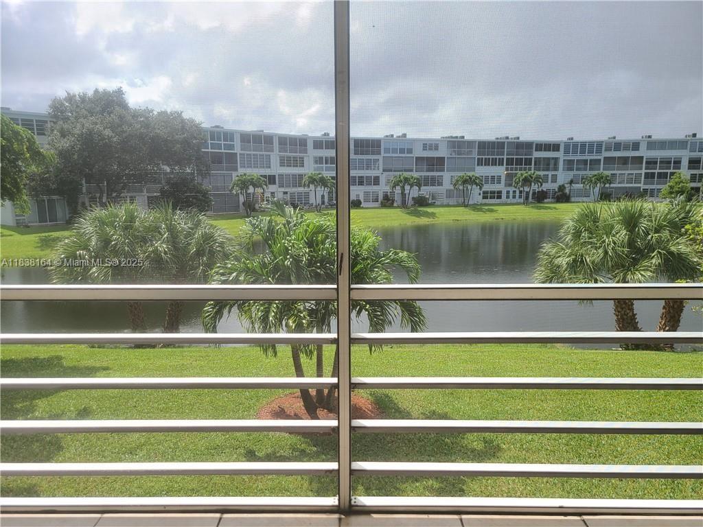 A view of a lake and apartment buildings from a screened-in balcony — 82 Oakridge G # 82, Deerfield Beach FL 33442, DEERFIELD BEACH, FL
