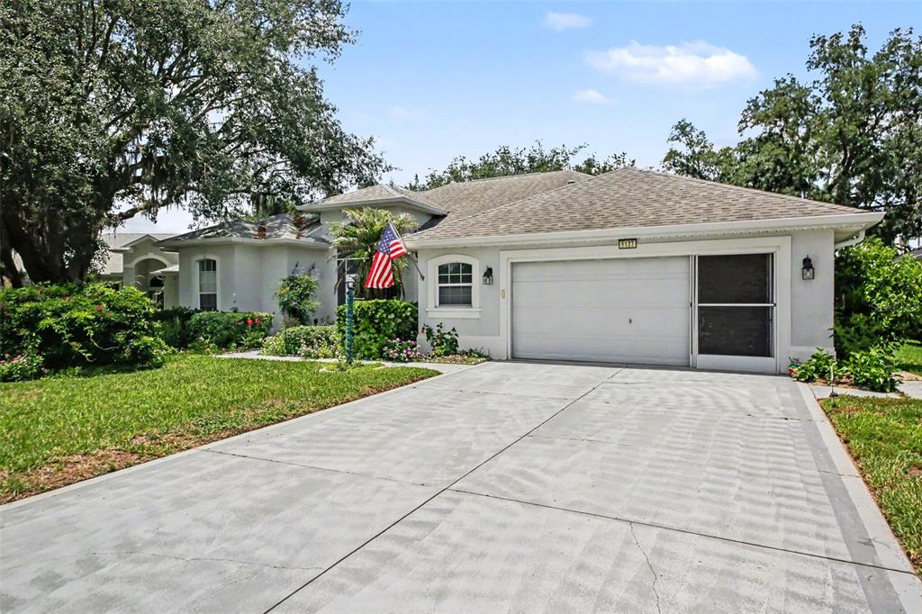 A single-story house with a two-car garage, a concrete driveway, and a front yard — 5127 AURORA DRIVE, LEESBURG, FL