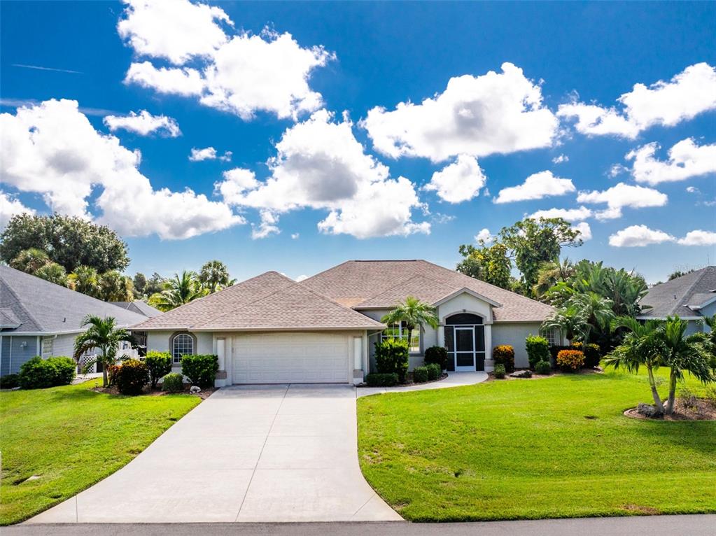A single-story suburban house features a two-car garage, a front entryway, and a manicured lawn — 8 SPORTSMAN ROAD, ROTONDA WEST, FL
