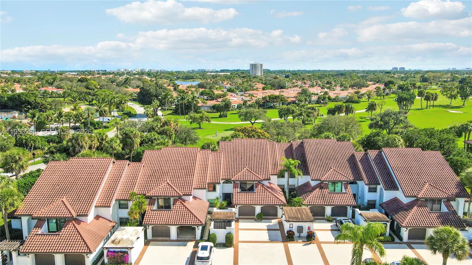 An aerial view shows a multi-unit townhouse complex with terracotta roofs overlooking a golf course — 16600 S Traders Xing S # 253, Jupiter FL 33477, JUPITER, FL