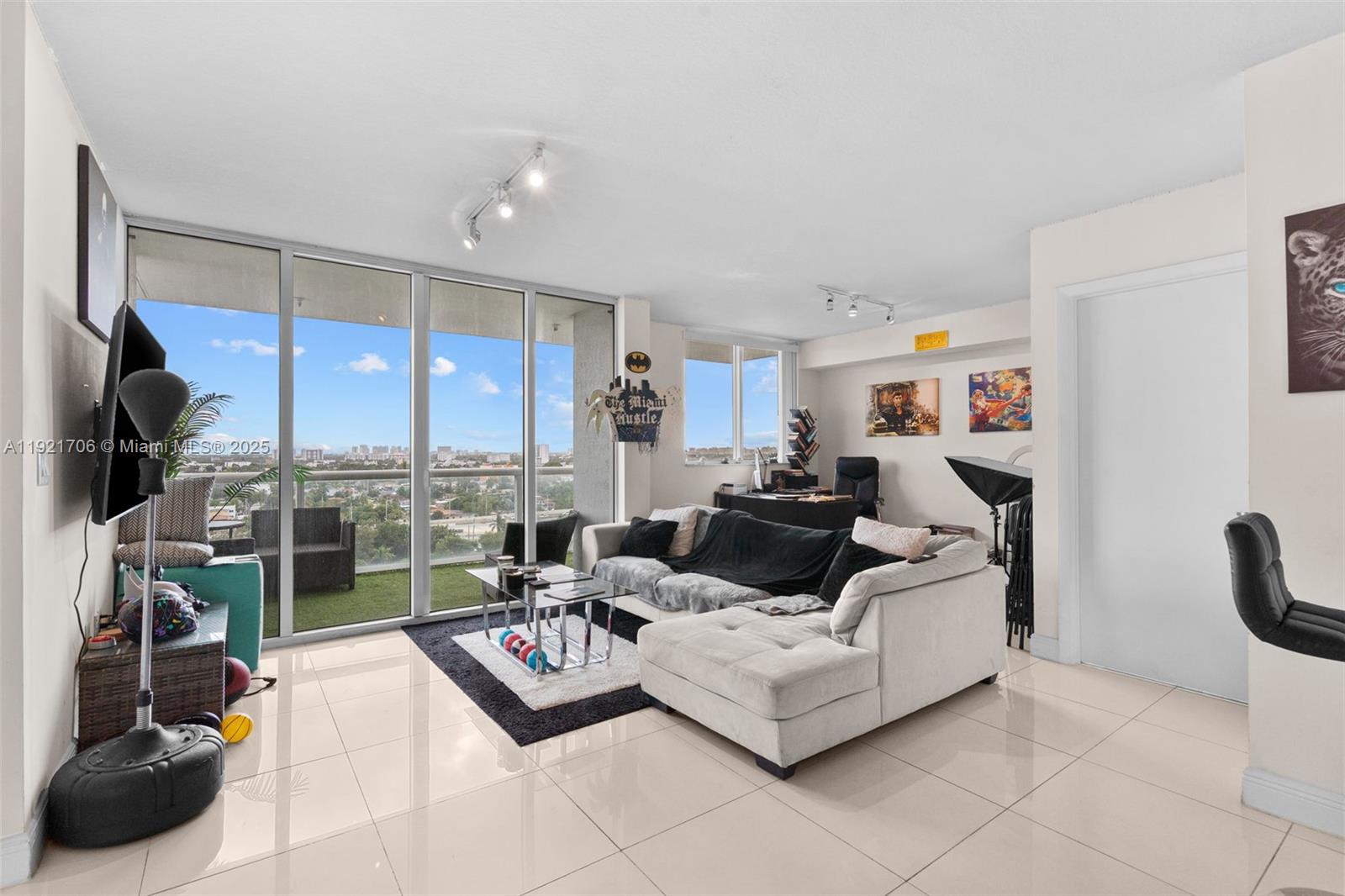 A living room features light tile floors, a sectional sofa, and floor-to-ceiling windows with balcony access — 1871 NW S River Dr # 1402, Miami FL 33125, MIAMI, FL