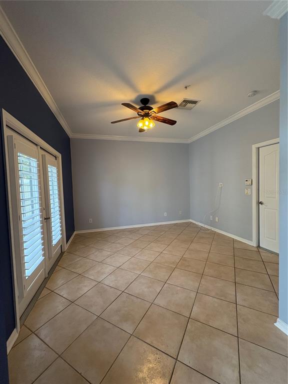 A room with light blue walls, a dark blue accent wall, tile flooring, and ceiling fan — 1407 HARBOUR WALK ROAD, TAMPA, FL