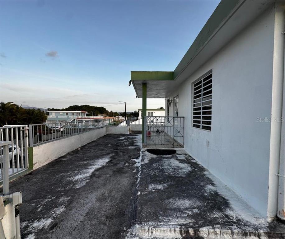 A concrete rooftop terrace features a metal railing and a covered porch area — 89 BLOCK 92 VILLA CAROLINA DEV. UNIT 11, CAROLINA, PR