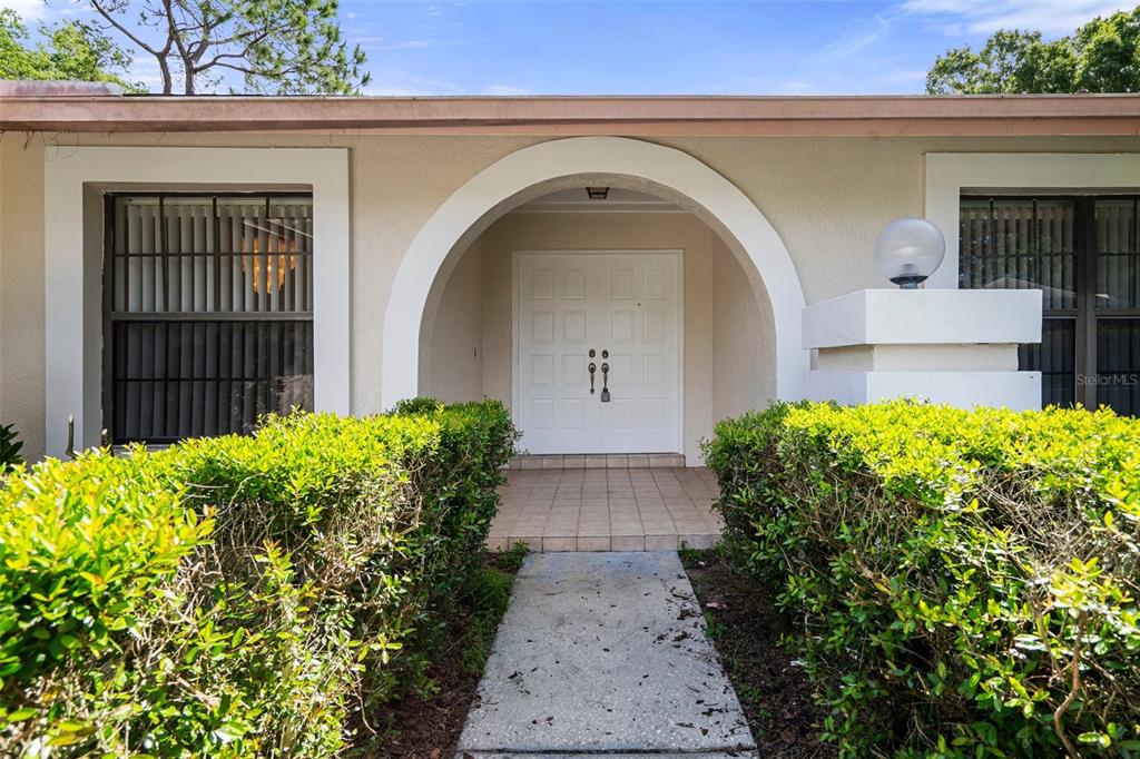 A kitchen features beige cabinets, a large range hood, a black refrigerator, and tiled floors — 16125 ANCROFT COURT, TAMPA, FL
