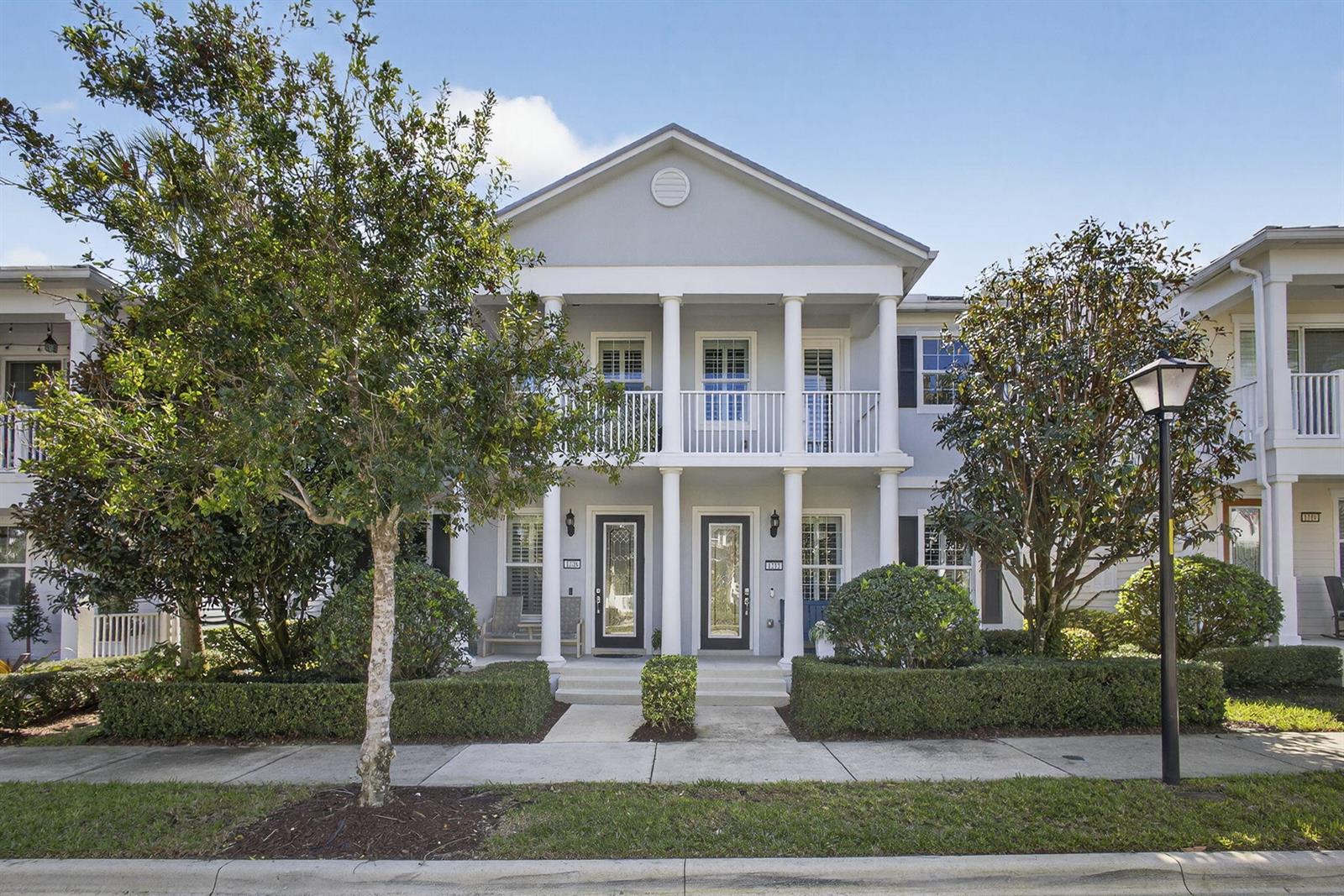 A two-story gray townhouse features a front porch with white columns and a balcony — 1208 Islamorada Drive, Jupiter FL 33458, JUPITER, FL