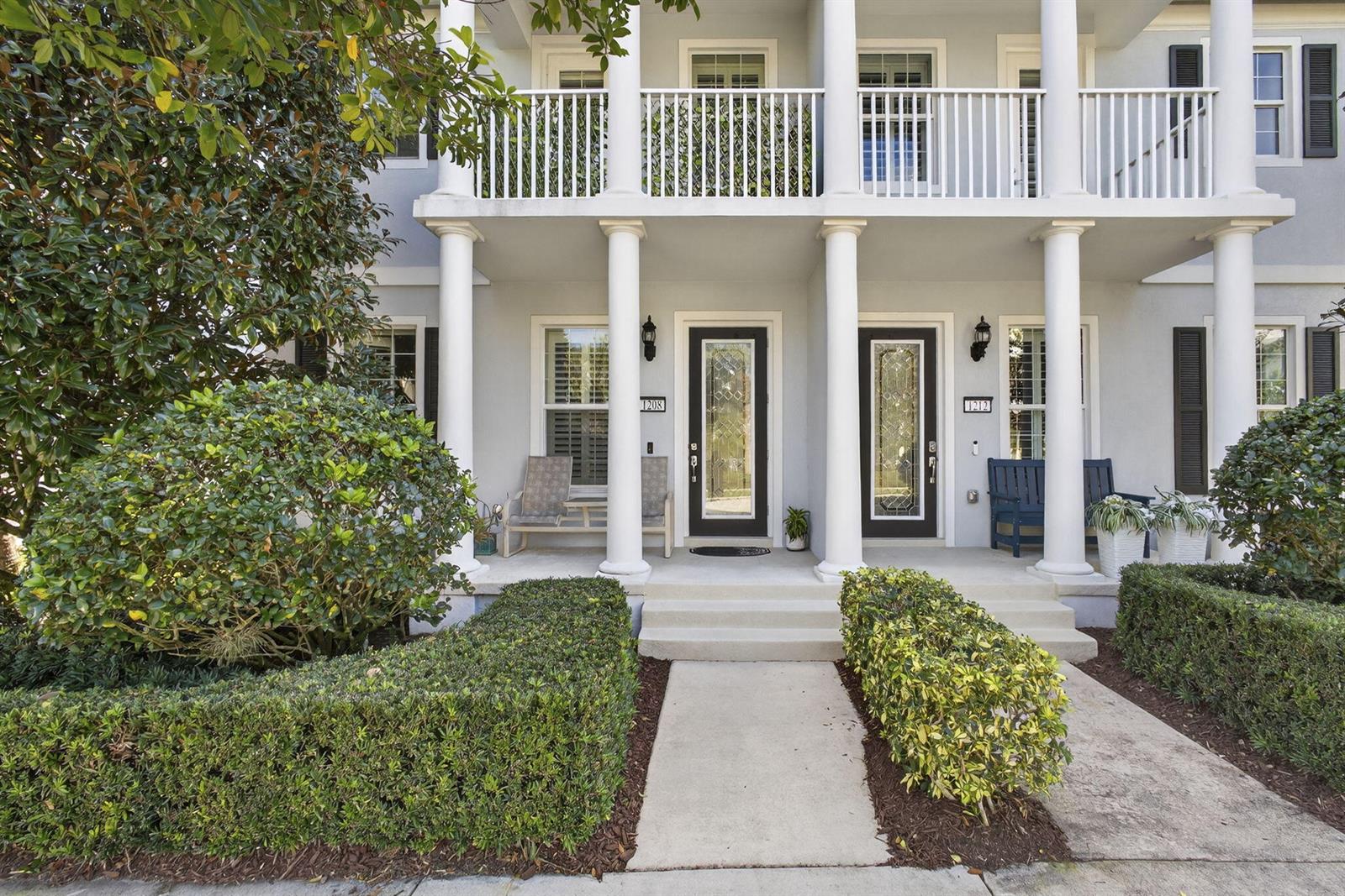 The exterior of a two-story building features a covered porch with white columns and railings — 1208 Islamorada Drive, Jupiter FL 33458, JUPITER, FL
