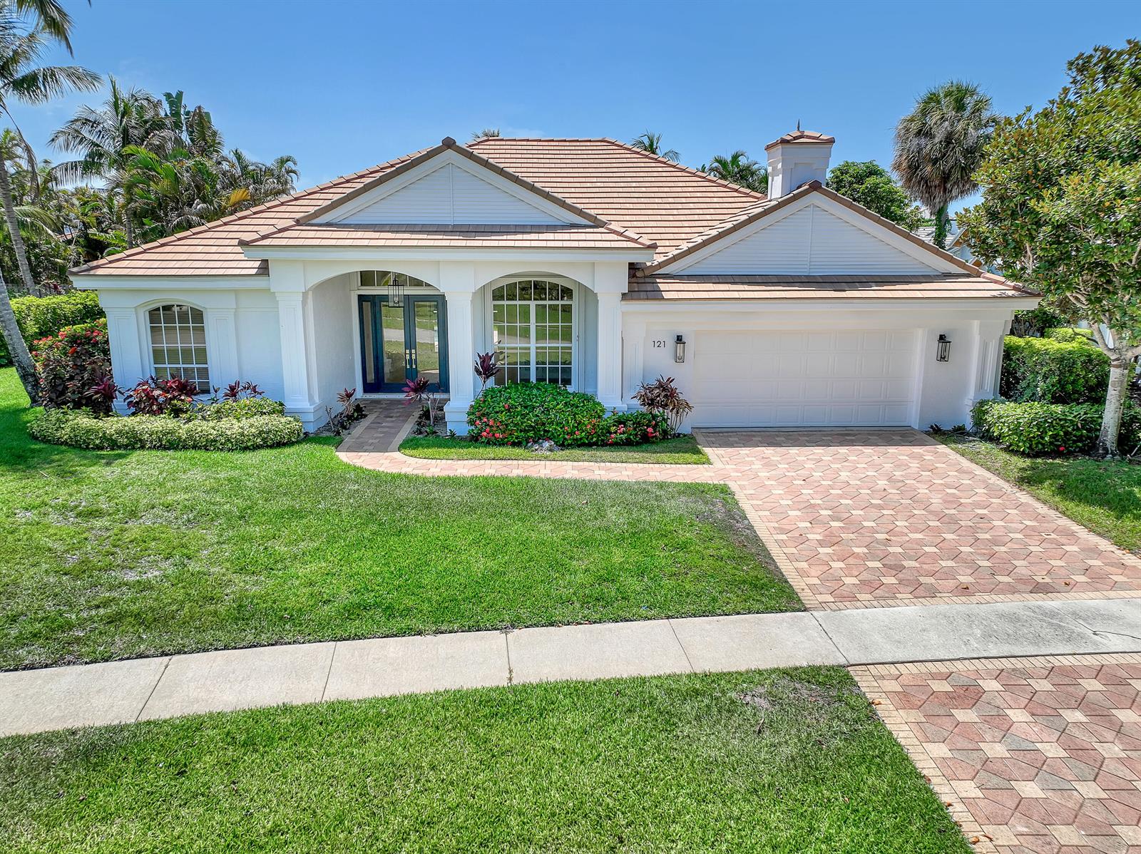 A single-story house with a white exterior, tiled roof, and a paved driveway — 121 Olympus Way, Jupiter FL 33477, JUPITER, FL