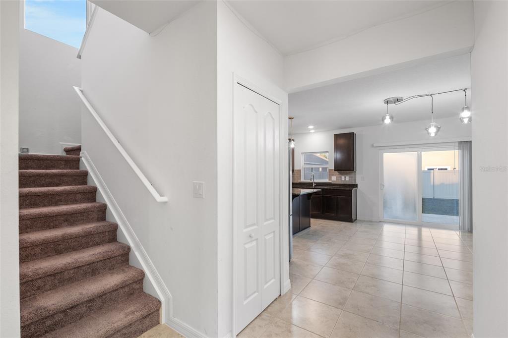 A kitchen features dark cabinetry, black countertops, a center island, and light-colored tile flooring — 2151 NW 248TH WAY, NEWBERRY, FL