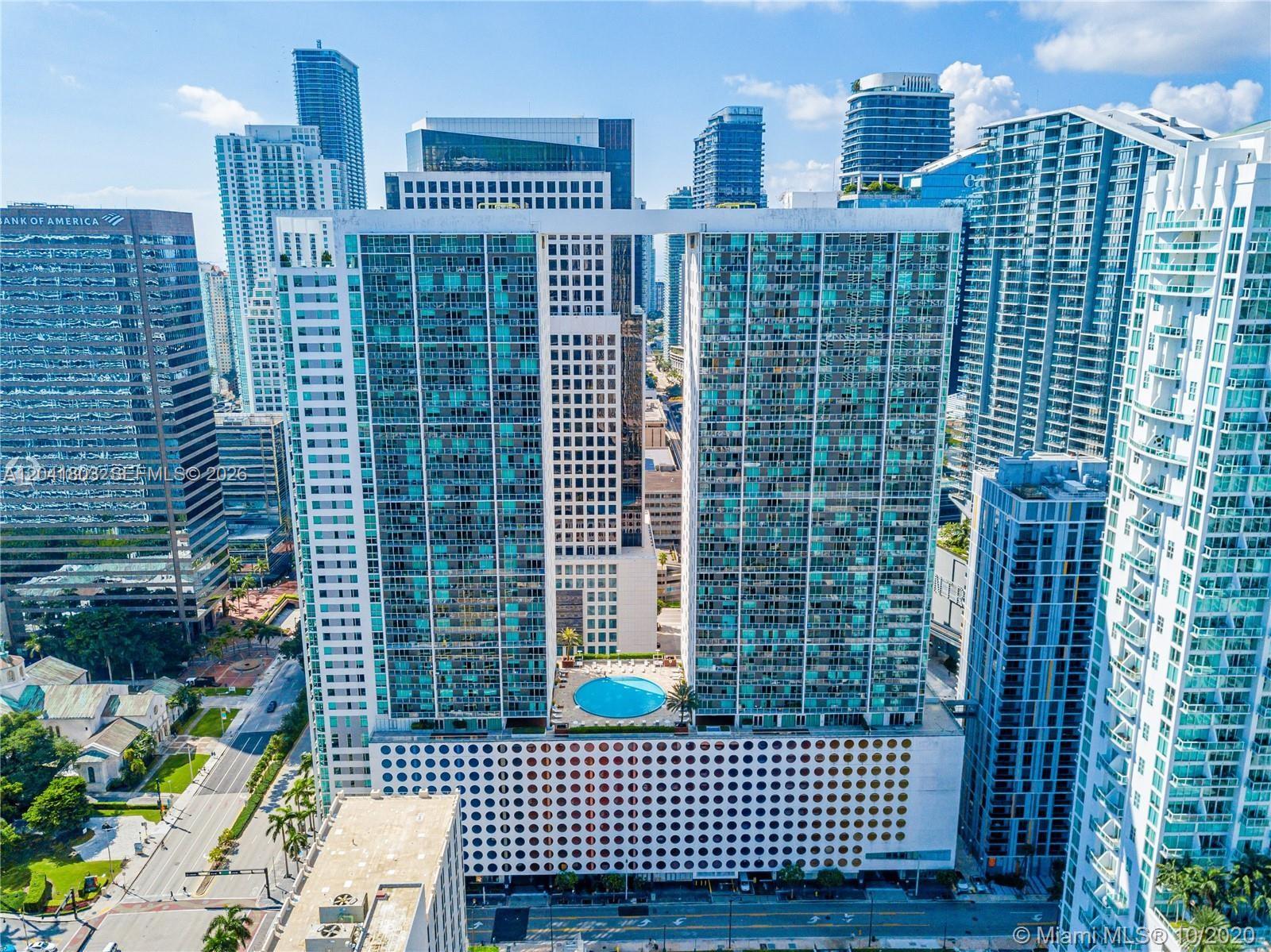 An aerial view shows a large residential building with a central pool deck and parking garage — 500 Brickell Ave # 2604, Miami FL 33131, MIAMI, FL