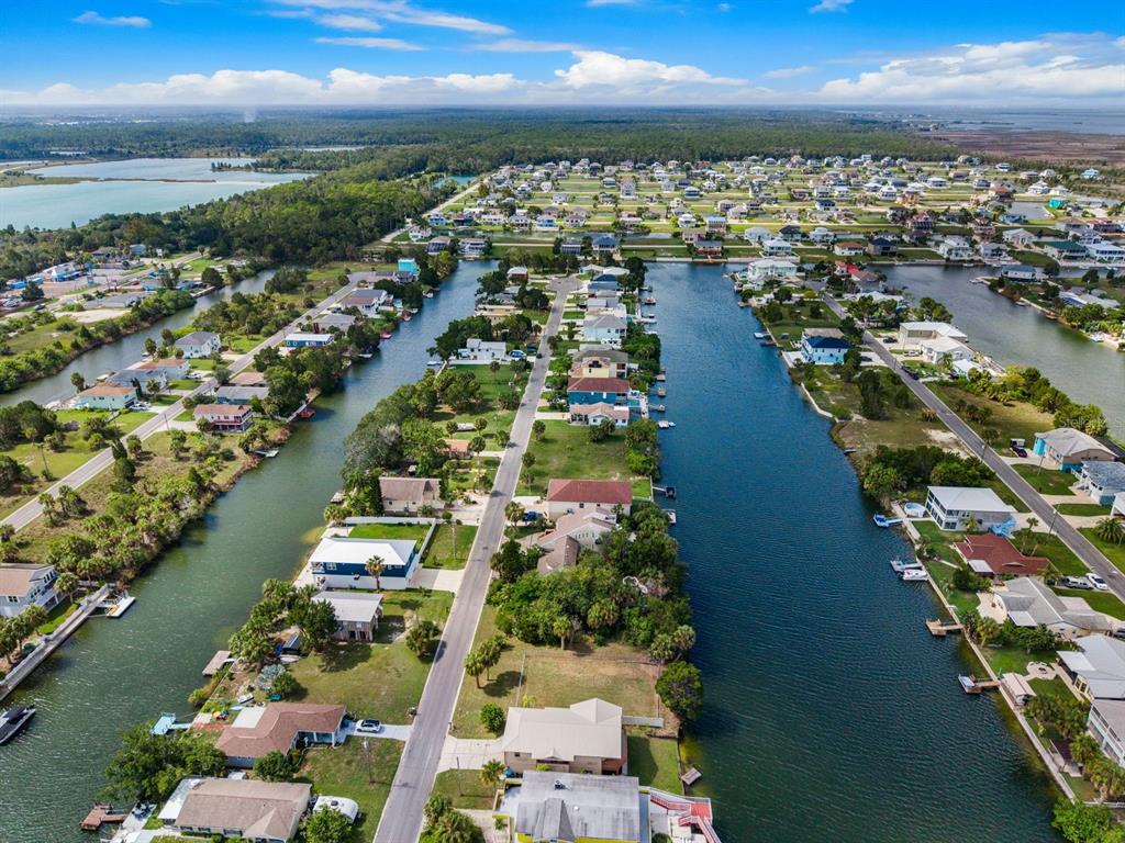 An aerial view shows waterfront homes lining canals in a residential neighborhood — 3287 SEA GRAPE DRIVE, HERNANDO BEACH, FL