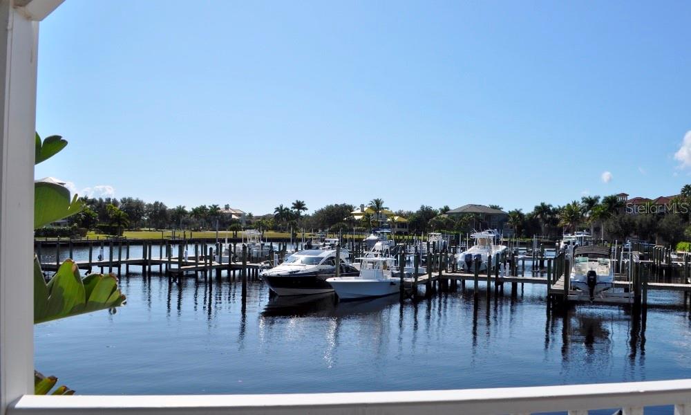 A view of a marina with multiple boats docked in the water under a clear sky — 21421 HARBORSIDE BOULEVARD, PORT CHARLOTTE, FL