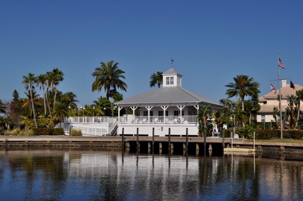 A white waterfront pavilion with a cupola sits above a wooden dock on a canal — 21421 HARBORSIDE BOULEVARD, PORT CHARLOTTE, FL