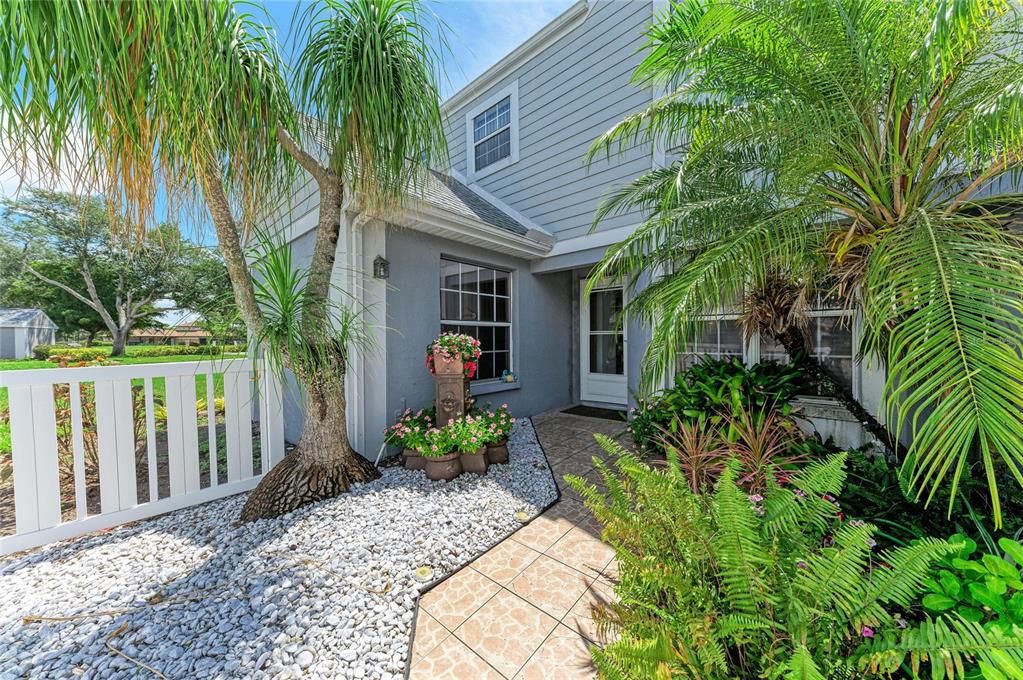 A paved walkway leads to the front entrance of a two-story house with landscaping — 5209 34TH STREET COURT W UNIT 261, BRADENTON, FL
