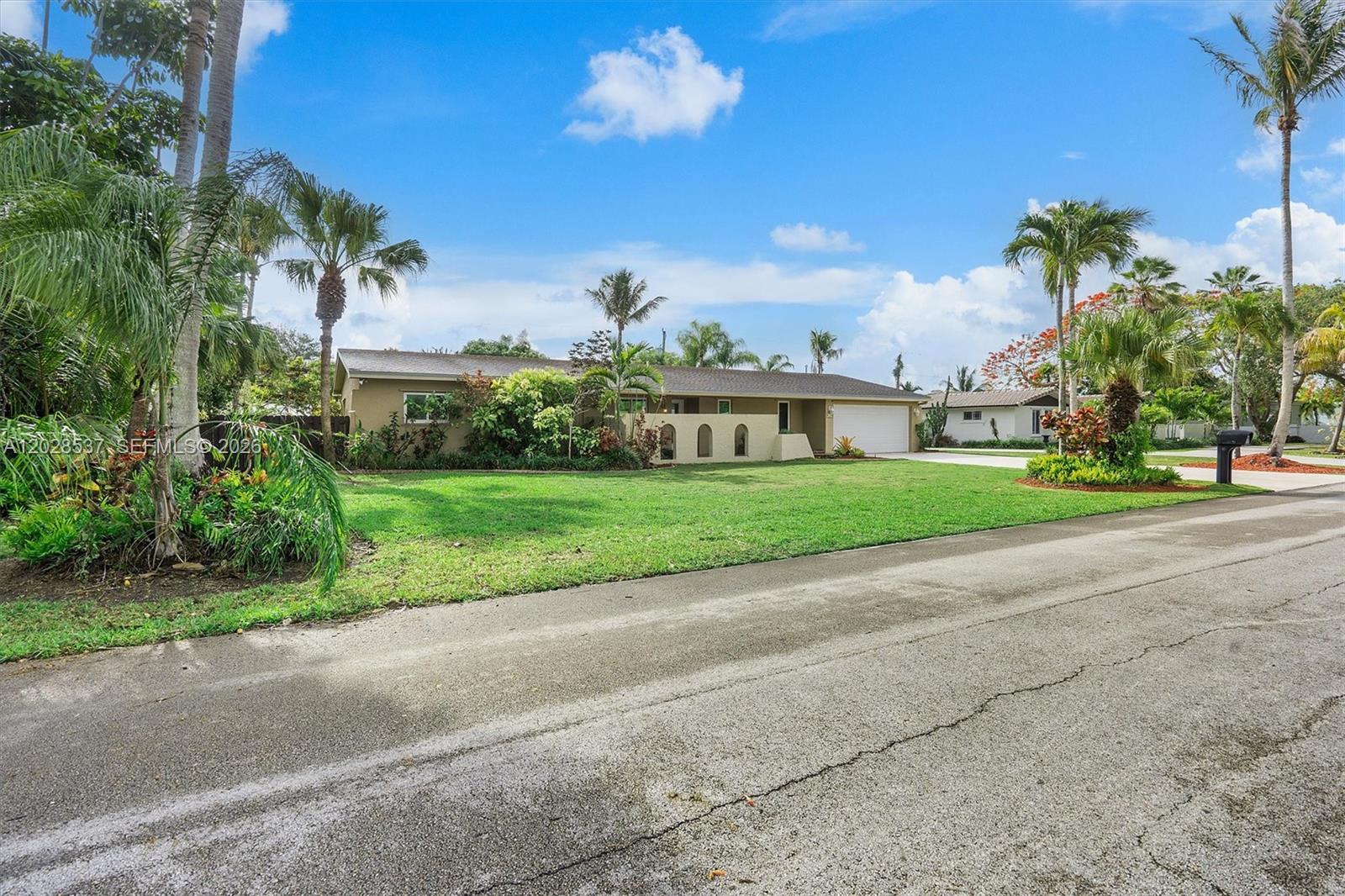 A single-story house with a tan exterior, arched wall details, and a two-car garage — 13241 SW 99th Ct, Miami FL 33176, MIAMI, FL