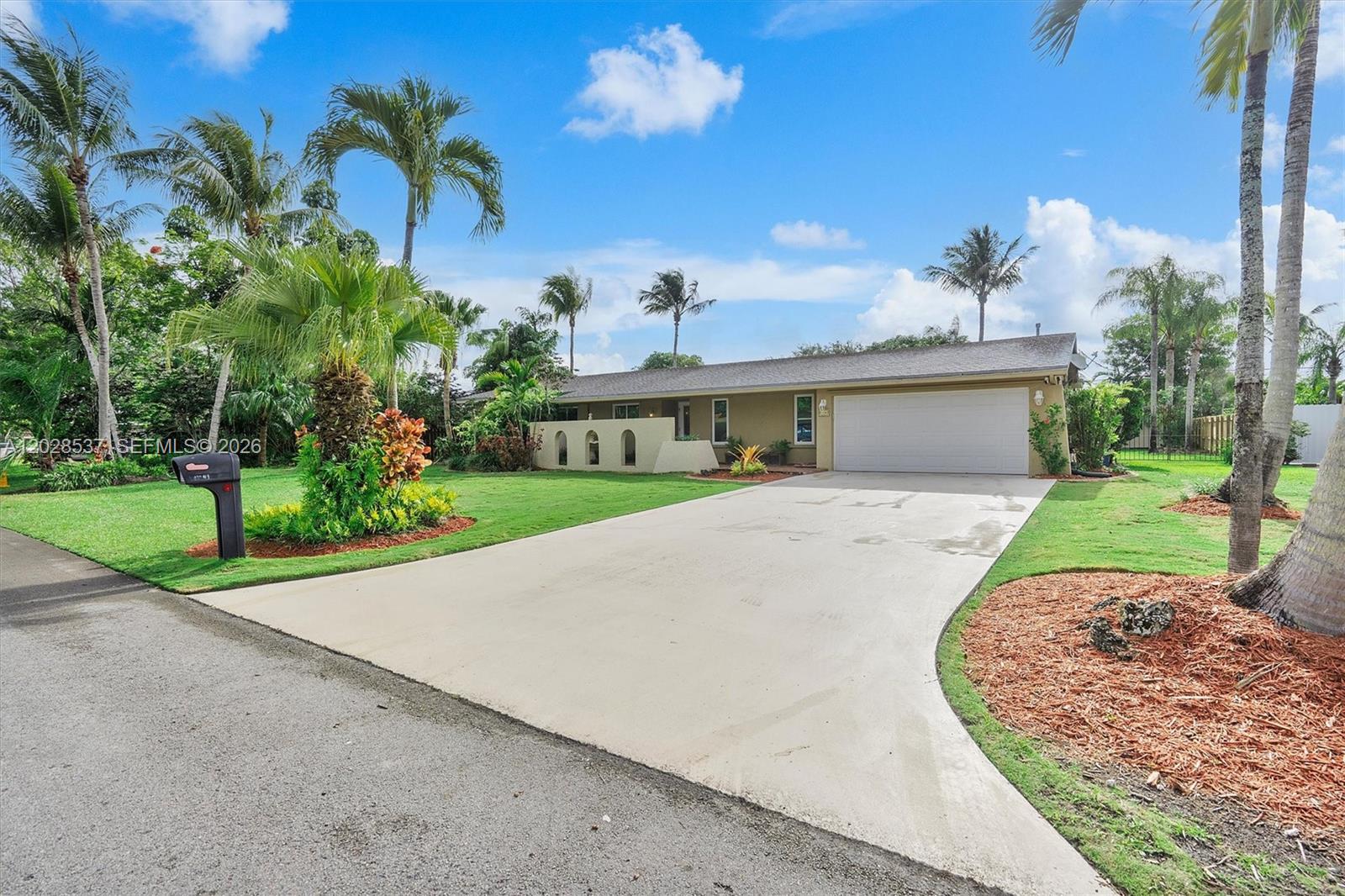 A single-story house with a white garage door, a concrete driveway, and several palm trees — 13241 SW 99th Ct, Miami FL 33176, MIAMI, FL