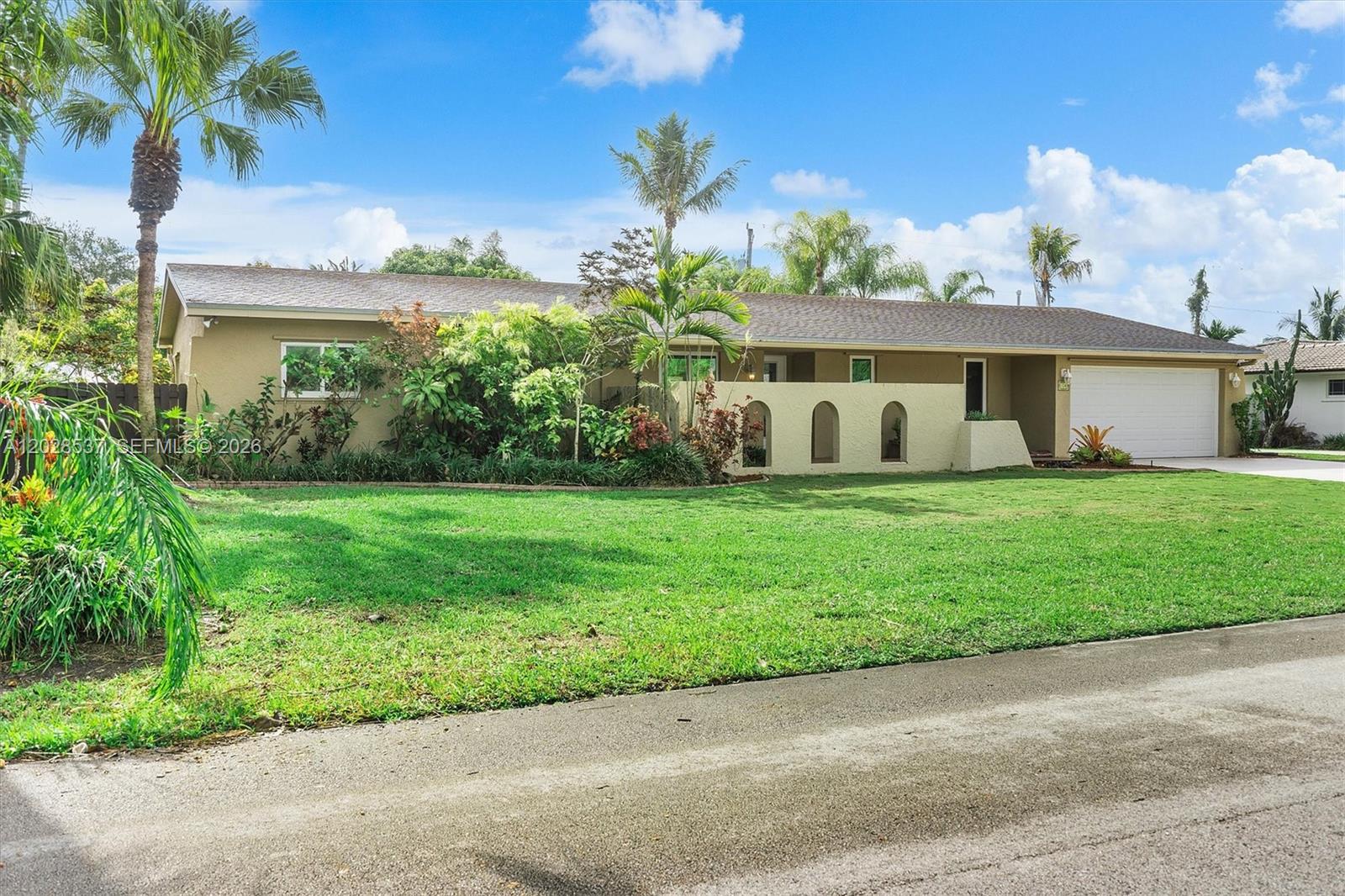 A single-story house with a tan exterior, arched wall accents, and a two-car garage — 13241 SW 99th Ct, Miami FL 33176, MIAMI, FL