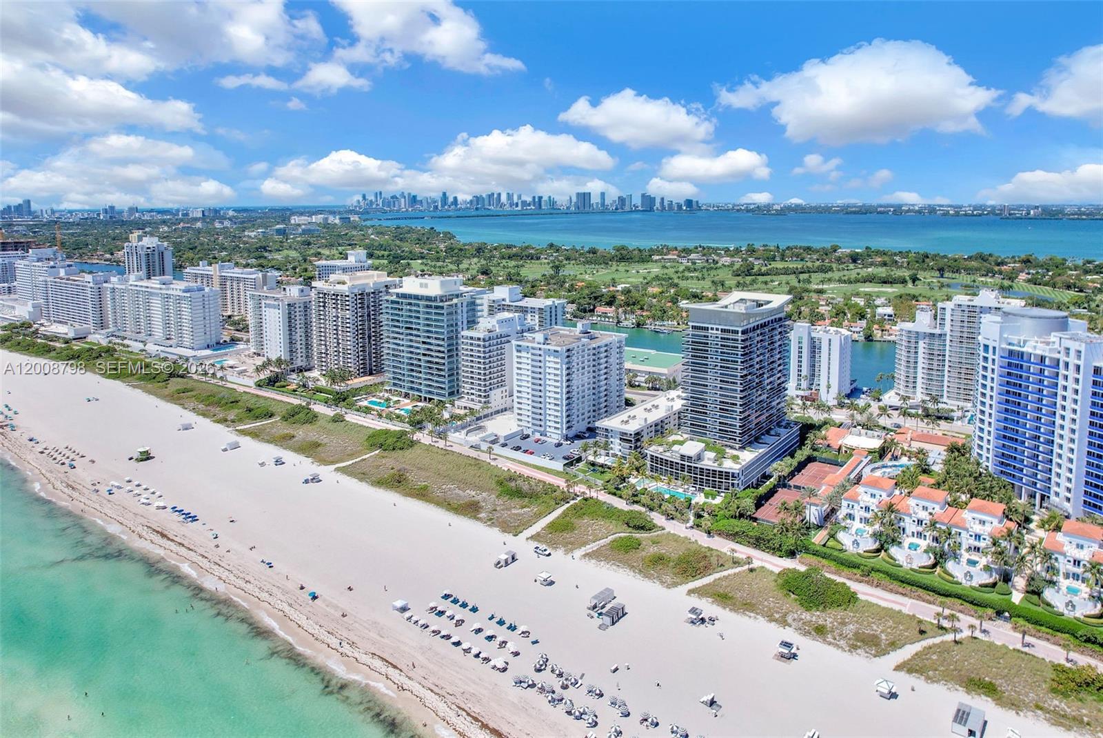 An aerial view shows a sandy beach, ocean, and several high-rise residential buildings — 5825 Collins Ave # 2E, Miami Beach FL 33140, MIAMI BEACH, FL