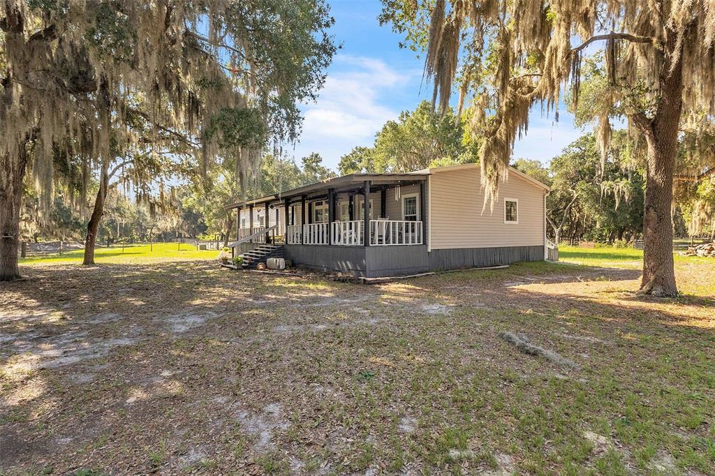 A single-story house with a covered porch sits on a grassy lot with trees — 601 PURVIS ROAD, SEVILLE, FL