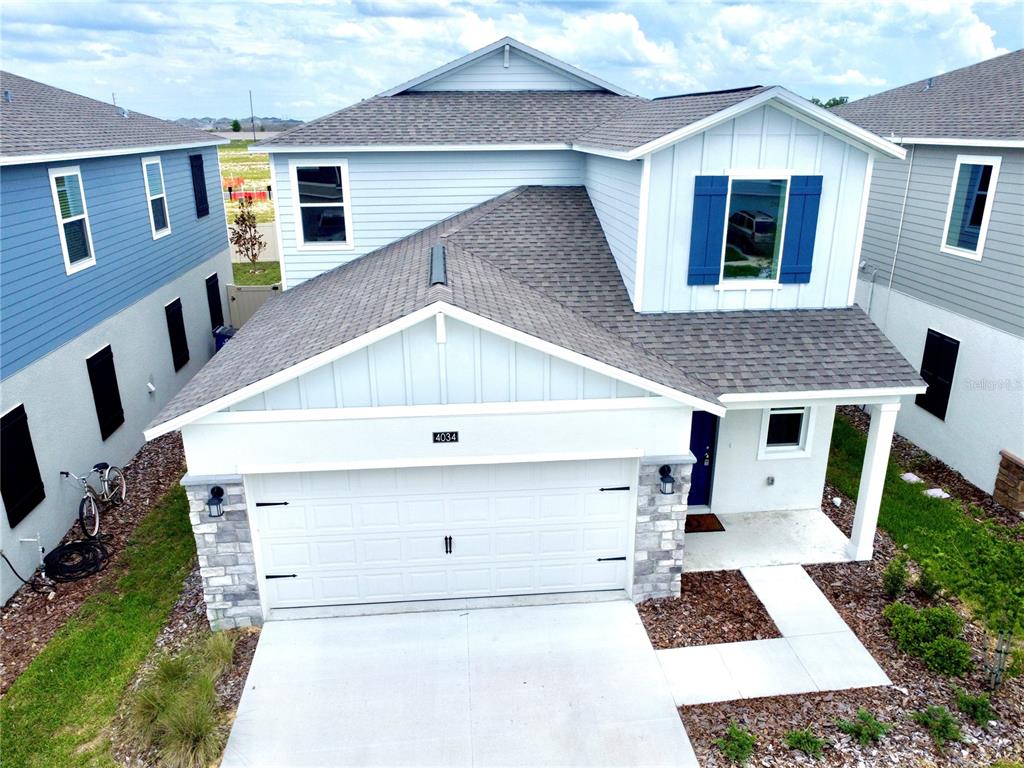 An aerial view of a two-story house with a light blue exterior and white garage — 4034 OLD MILL ROAD, HAINES CITY, FL