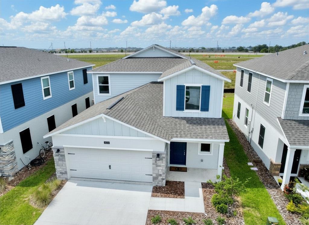 An aerial view of a two-story suburban house with a white garage and blue shutters — 4034 OLD MILL ROAD, HAINES CITY, FL
