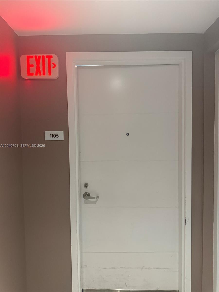 A white door with a peephole and handle is labeled with the number 1105 — SUNNY ISLES BEACH, FL