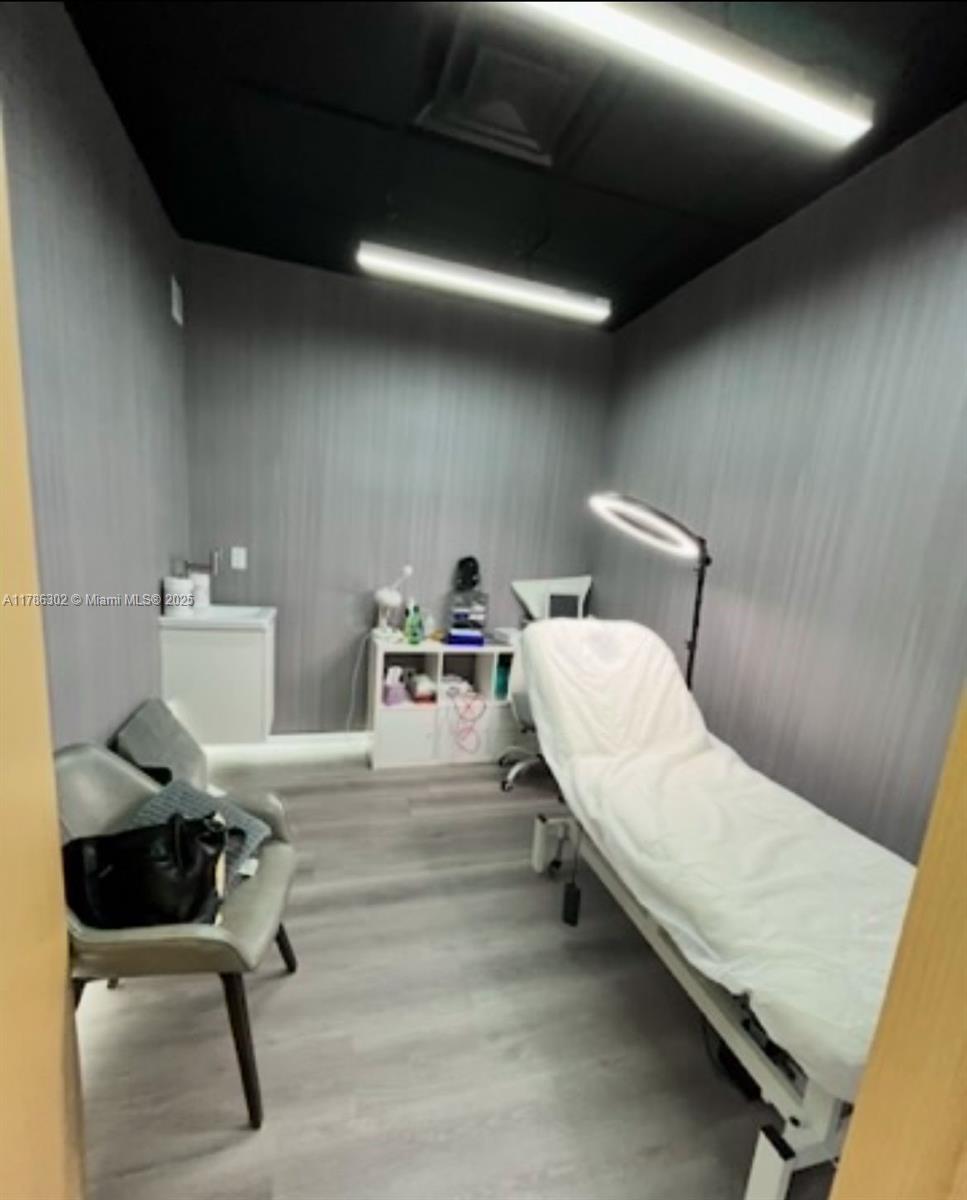 A small treatment room features a massage table, a chair, and a white storage unit — Confidential, West Miami FL 33144, WEST MIAMI, FL
