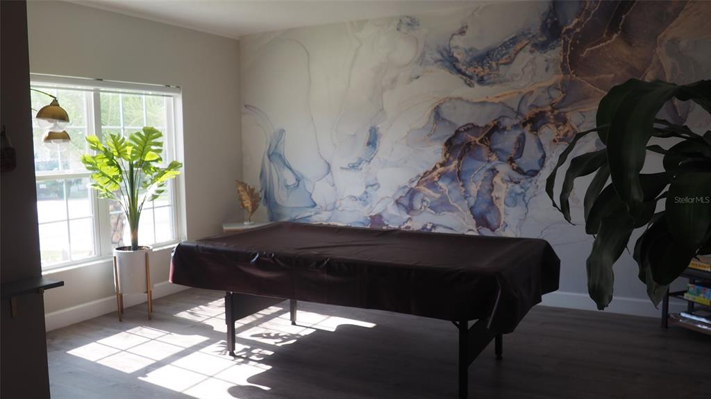 A room features a pool table covered in a brown cloth against a marble-patterned accent wall — 216 DENALI STREET, HAINES CITY, FL