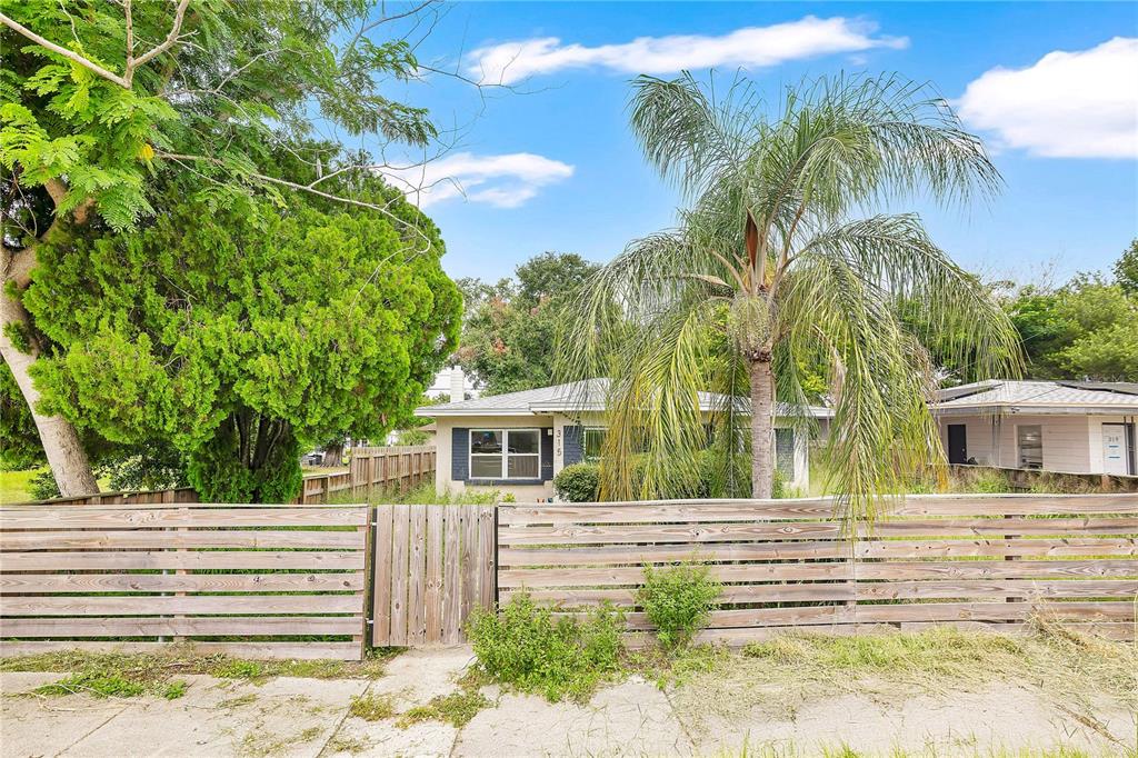 A single-story house with a wooden fence and a palm tree in the front yard — 315 E STREET, LAKE WALES, FL
