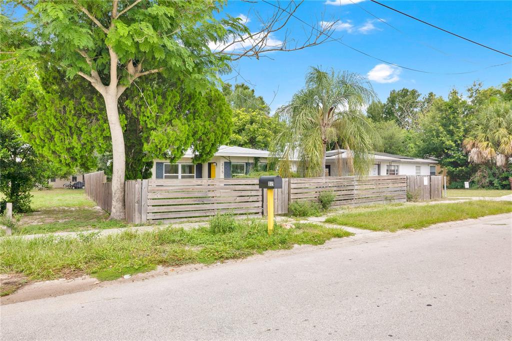 A single-story house with a wooden fence and a large tree in the front yard — 315 E STREET, LAKE WALES, FL