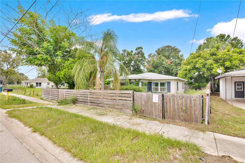 A single-story house with a wooden fence and a palm tree in the front yard — 315 E STREET, LAKE WALES, FL