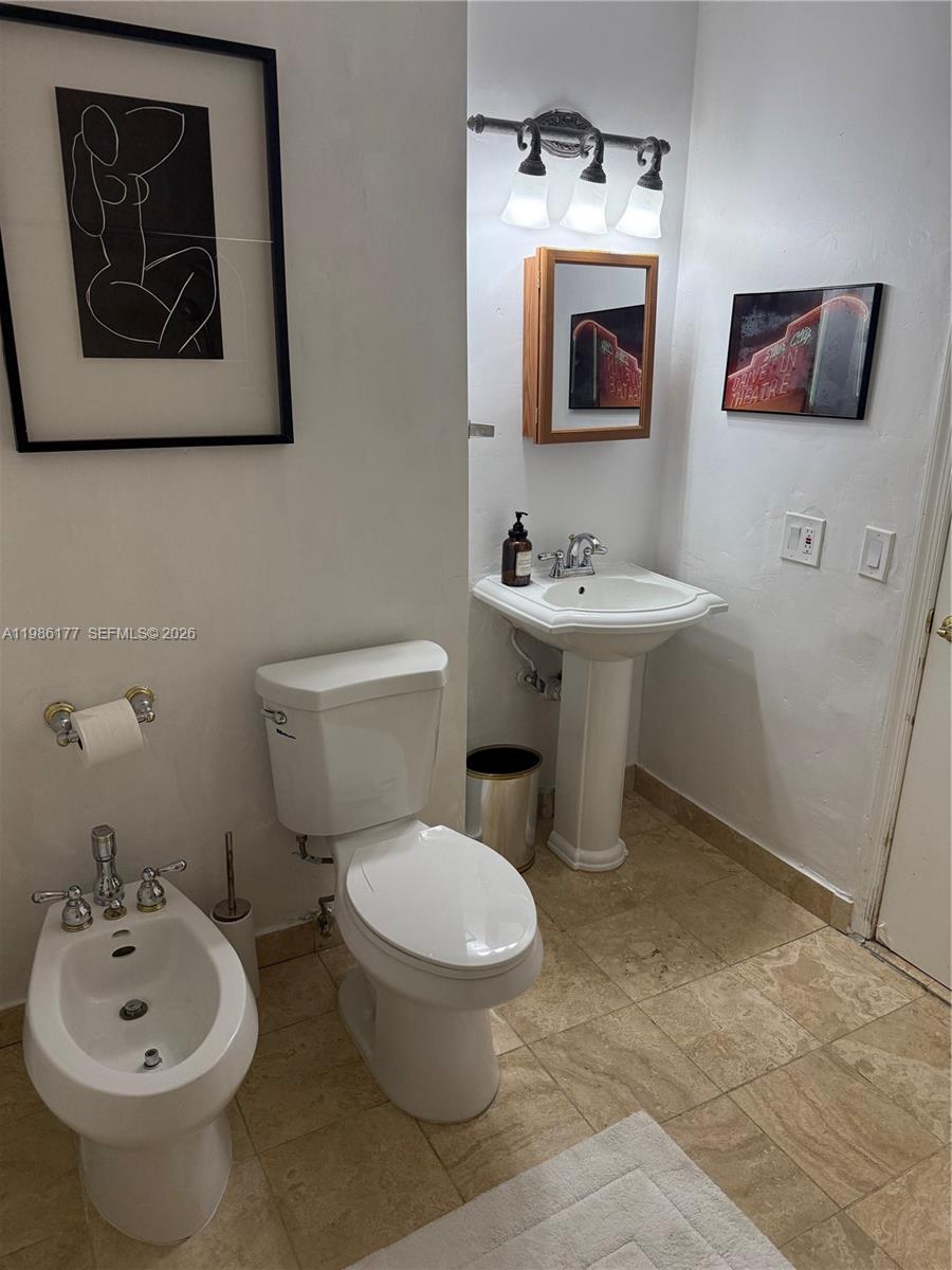 A bathroom features a pedestal sink, a toilet, a bidet, and tiled flooring — 1208 Bird Rd, Coral Gables FL 33146, CORAL GABLES, FL