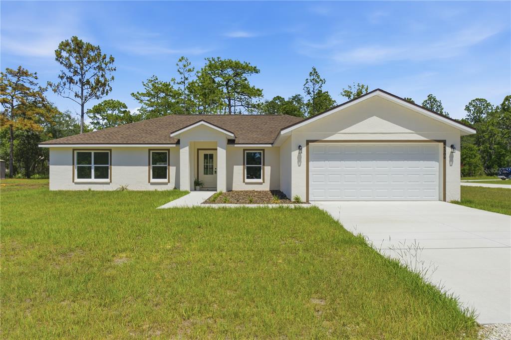 A single-story house with a white stucco exterior, brown roof, and attached two-car garage — 14586 MOCKING WREN ROAD, WEEKI WACHEE, FL