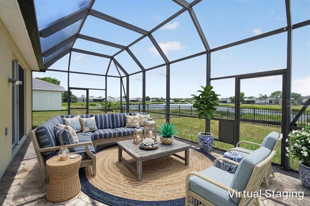 A screened-in patio features a virtual staging of outdoor furniture overlooking a pond and yard — 9780 50TH STREET CIRCLE E, PARRISH, FL