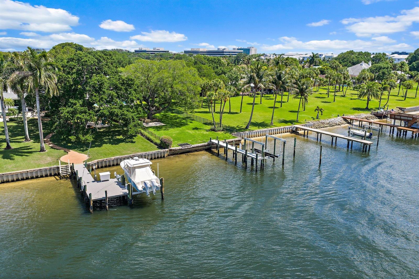 An aerial view shows a grassy waterfront property with multiple boat docks and palm trees — 2162 Radnor Road, North Palm Beach FL 33408, NORTH PALM BEACH, FL