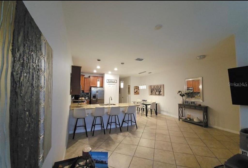 A two-story tan townhouse with brown shutters and a large tree in the front yard — 4393 FENNWOOD CT, WESLEY CHAPEL, FL