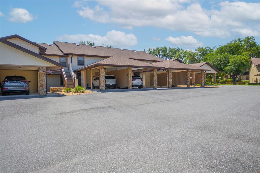 A multi-unit residential building features covered parking spaces and stone-accented support columns — 270 E GLASSBORO COURT UNIT 2B, HERNANDO, FL
