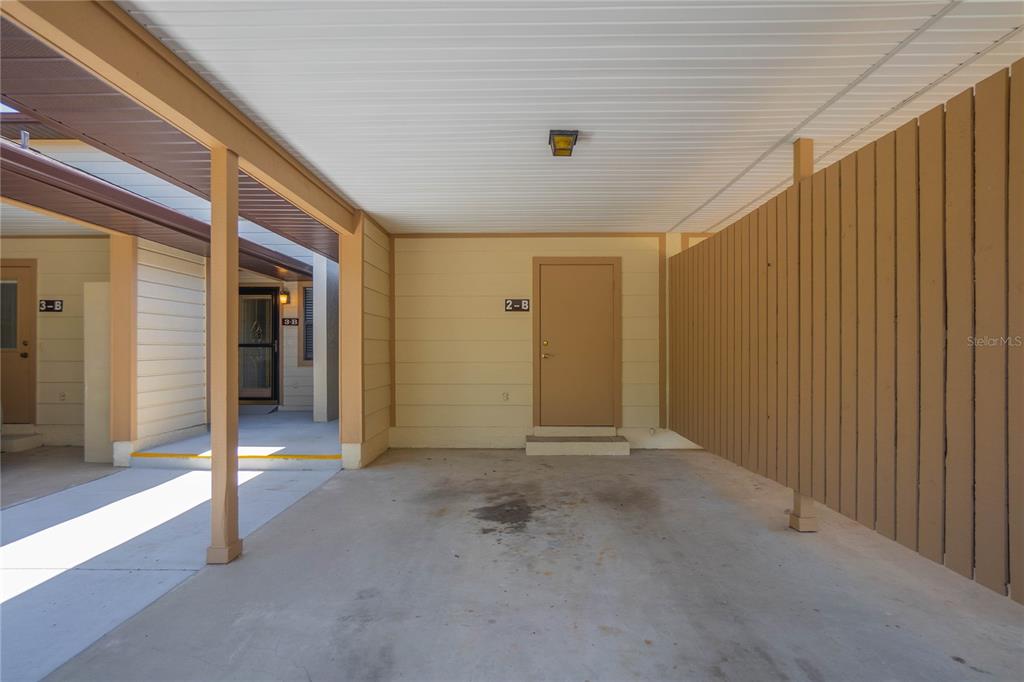 A covered carport area features a concrete floor, a tan door labeled 2-B, and wood siding — 270 E GLASSBORO COURT UNIT 2B, HERNANDO, FL