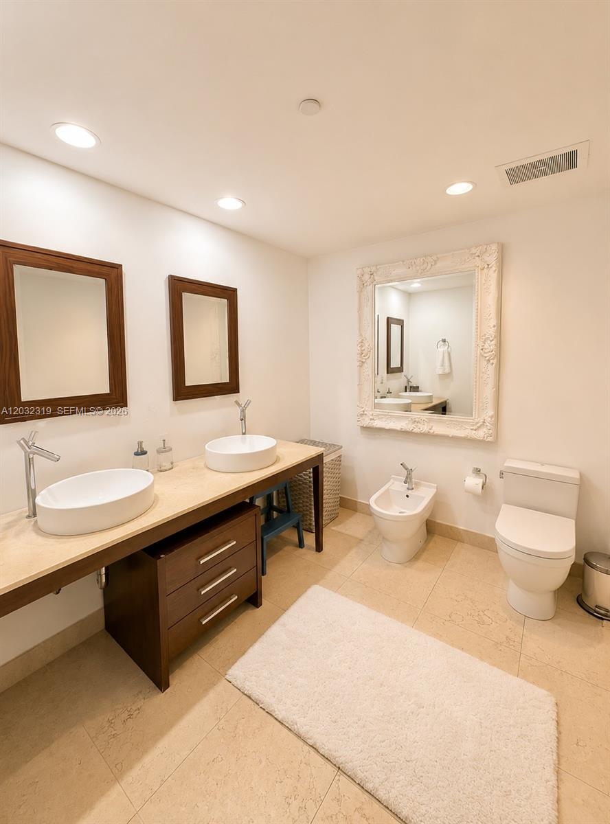 A bathroom features a double vanity with vessel sinks, a bidet, and a toilet — 495 Brickell Ave # 3206, Miami FL 33131, MIAMI, FL