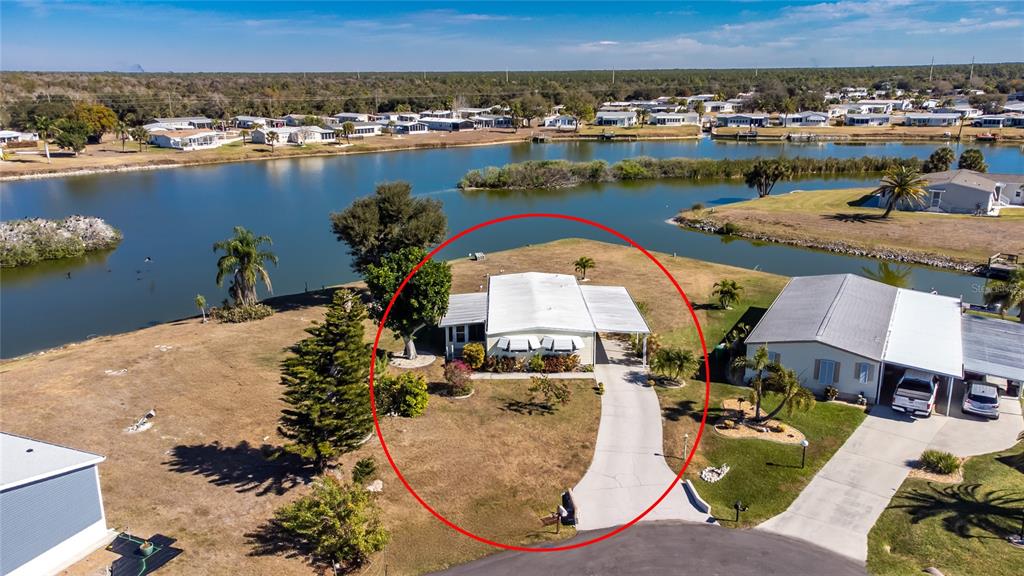 An aerial view shows a single-story house with a white roof and attached carport — 1300 SANDERLING DRIVE, ENGLEWOOD, FL