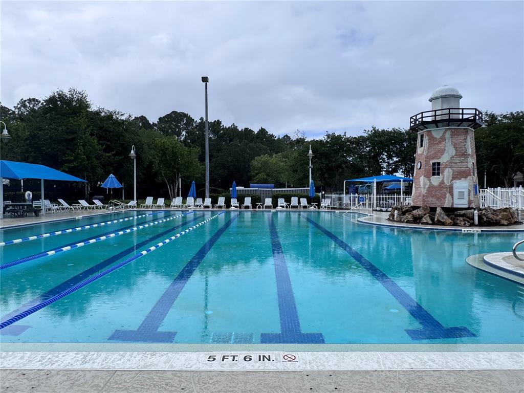 A swimming pool with lap lanes features a decorative lighthouse structure on the pool deck — 862504 N HAMPTON CLUB WAY, FERNANDINA BEACH, FL