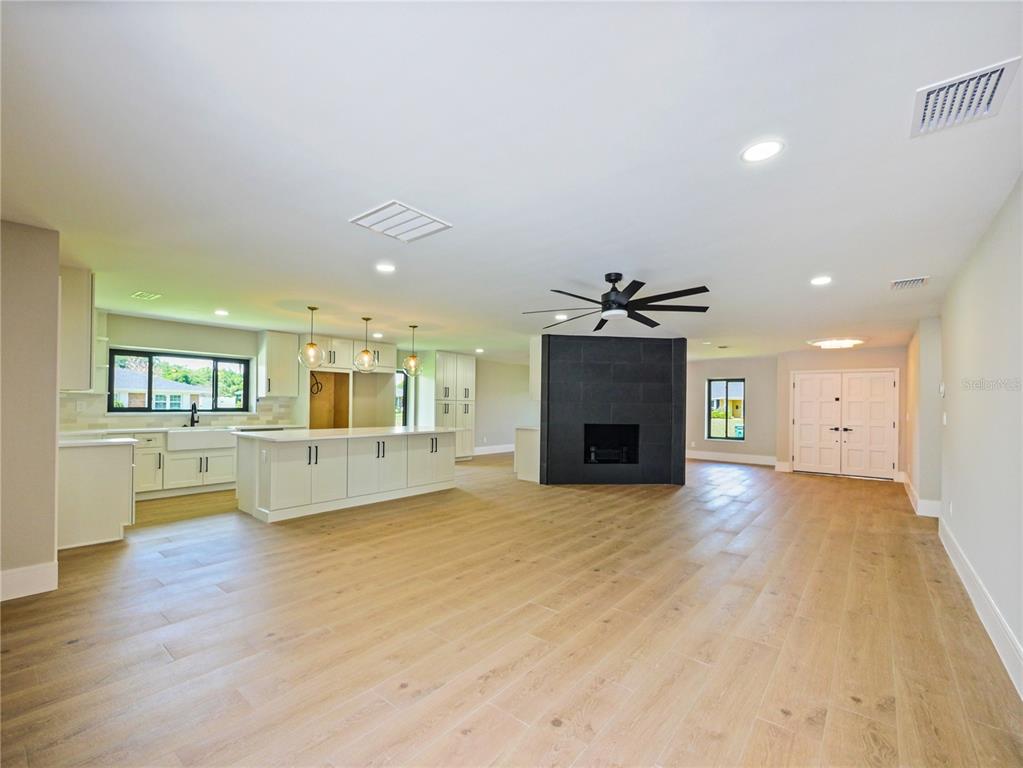 An open-concept living area features a kitchen with an island and a black fireplace — 2491 LAUDER DRIVE, MAITLAND, FL