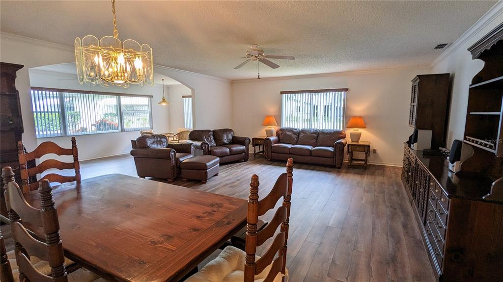 A dining area with a wooden table leads into a living room with leather furniture — 1624 LAYTON COURT UNIT 1624, SUN CITY CENTER, FL