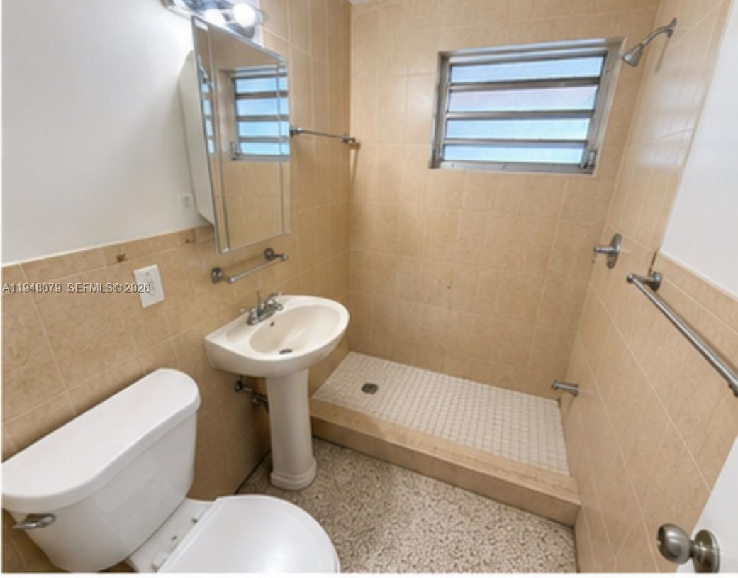 A small bathroom features a pedestal sink, a toilet, and a tiled walk-in shower — 5181 NW 5th St, Miami FL 33126, MIAMI, FL