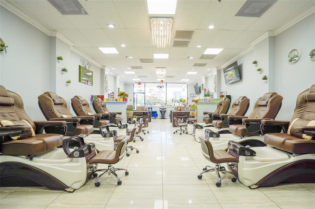 A nail salon interior features rows of pedicure chairs with brown upholstery on tiled floors — 865 FL-436, CASSELBERRY, FL