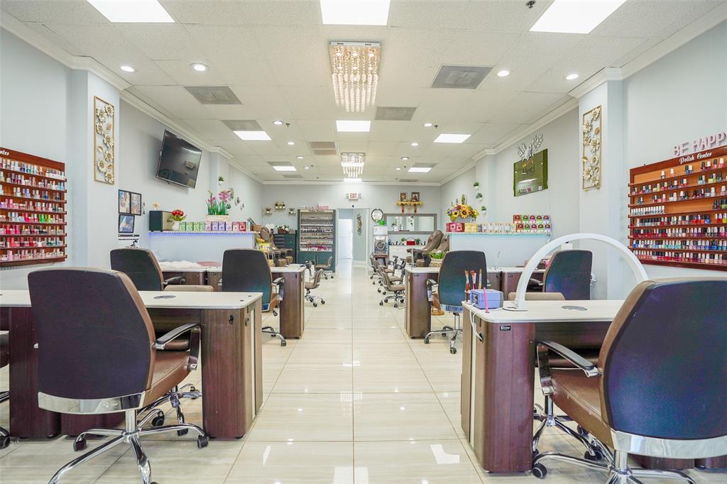 A nail salon interior features multiple manicure stations, rolling chairs, and wall-mounted polish displays — 865 FL-436, CASSELBERRY, FL