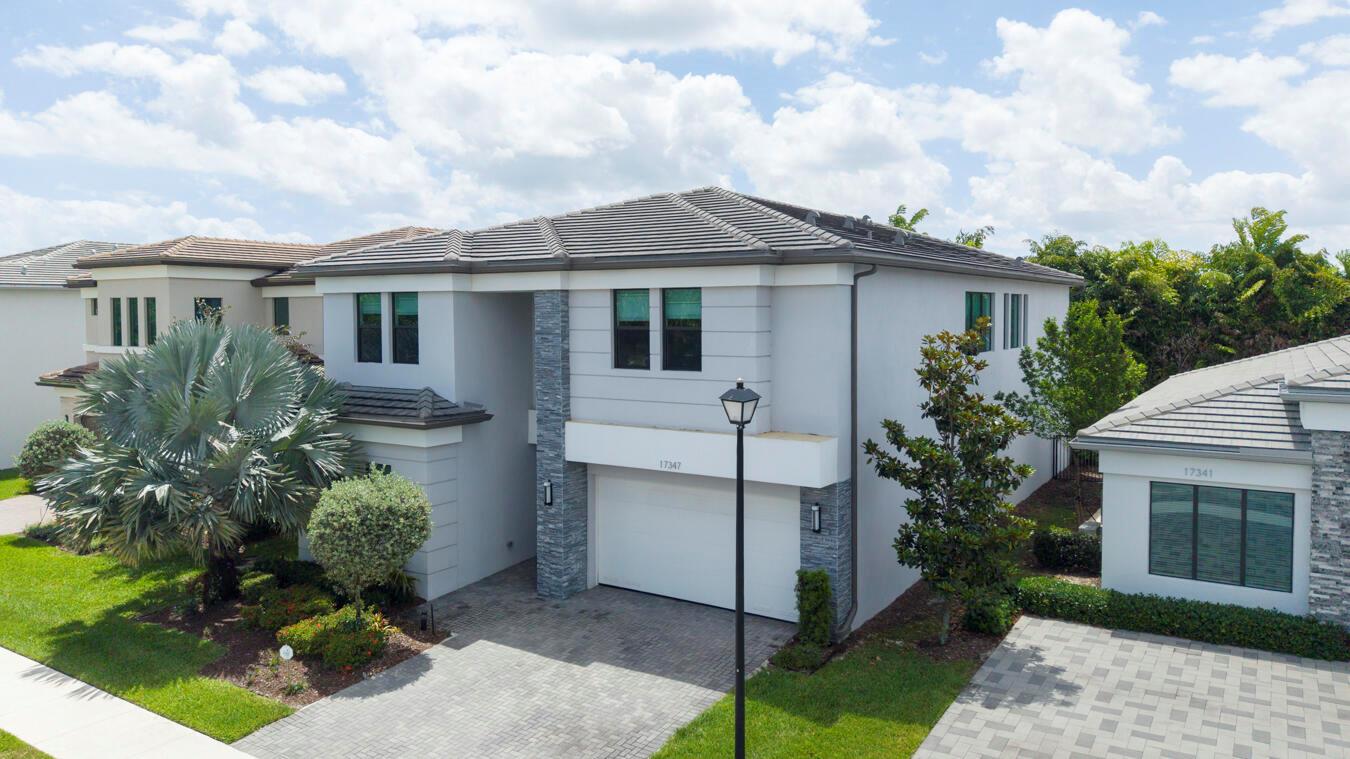 A two-story suburban house with a gray stucco exterior, stone accents, and a paved driveway — 17347 Sparkling River Road, Boca Raton FL 33496, BOCA RATON, FL