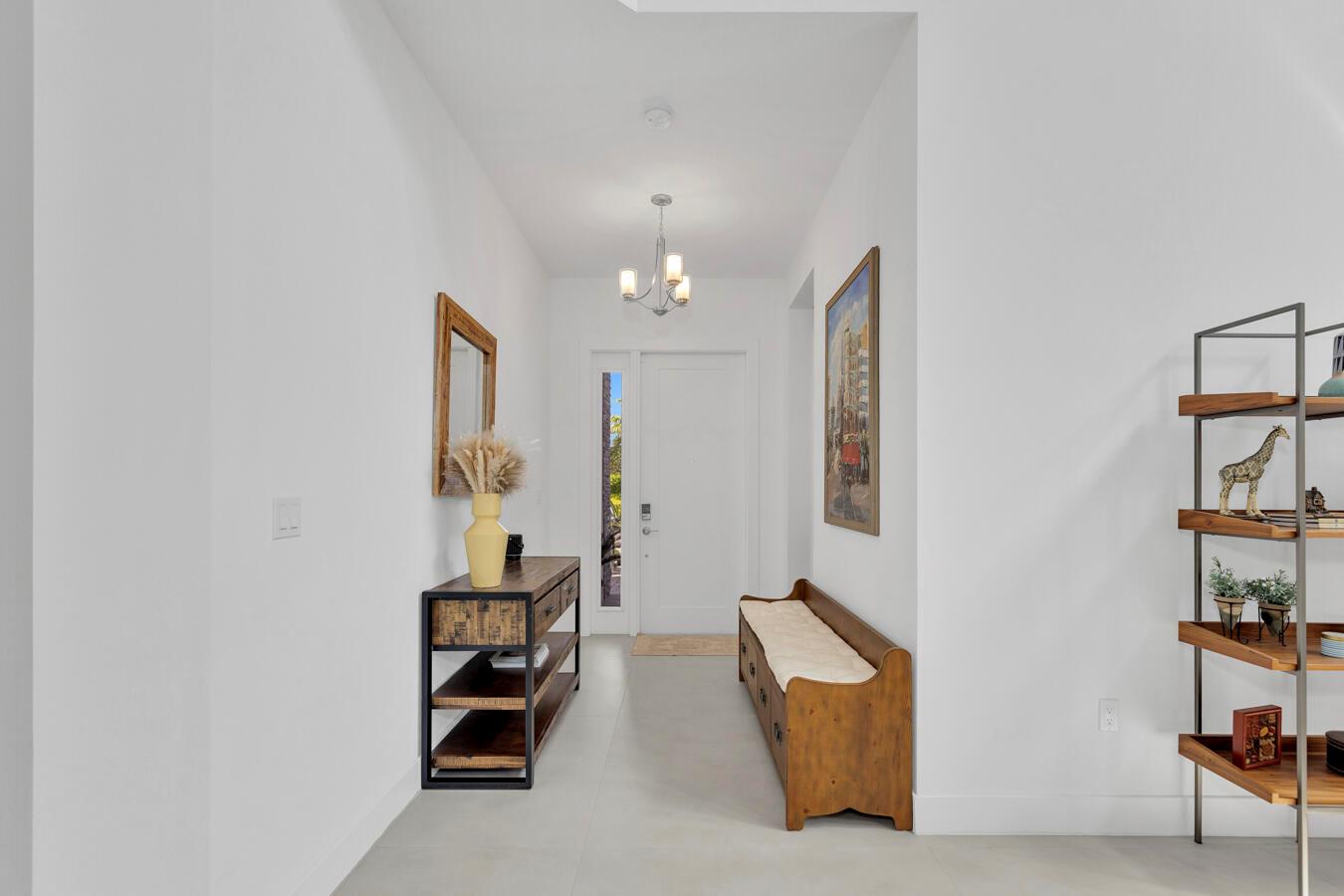 A bright entryway features a white door, a wooden bench, a console table, and shelving — 17347 Sparkling River Road, Boca Raton FL 33496, BOCA RATON, FL