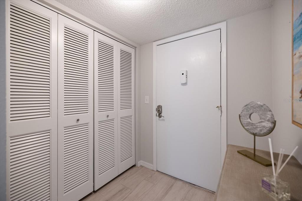 A white entry door sits next to a set of white louvered closet doors — 1604 STICKNEY POINT ROAD UNIT 102, SARASOTA, FL