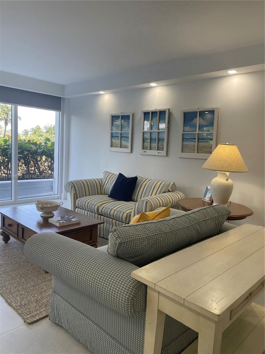 A living room features two patterned sofas, a wooden coffee table, and three window-pane wall decorations — 10275 Collins Ave # 208, Bal Harbour FL 33154, BAL HARBOUR, FL