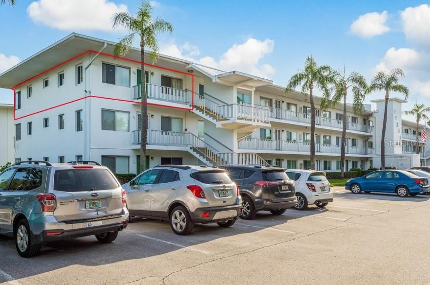 A multi-story apartment building with exterior walkways and a parking lot in the foreground — 11251 80TH AVENUE UNIT 310, SEMINOLE, FL